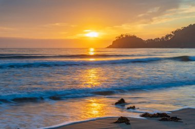 Avustralya, NSW 'nin güney kıyısındaki Malua Koyu' nda hafif bulutlu Sunrise Seascape.