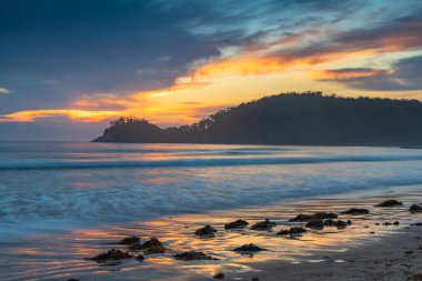 Avustralya, NSW 'nin güney kıyısındaki Sörf Sahili' nde Bulutlu Yaz Gündoğumu Deniz Burnu