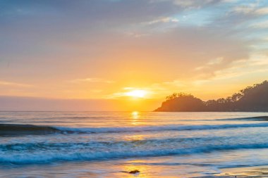 Avustralya, NSW 'nin güney kıyısındaki Sörf Sahili' nde Bulutlu Yaz Gündoğumu Deniz Burnu