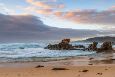 Avustralya, NSW 'nin güney kıyısındaki Eurobadalla Shire' de Bermagui 'de bulutlu ve dalgalı gün doğumu deniz manzarası..