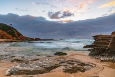 Avustralya, NSW 'nin güney kıyısındaki Eurobadalla Shire' de Bermagui 'de bulutlu ve dalgalı gün doğumu deniz manzarası..