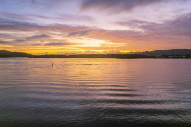 Kuzey Sahili, Avustralya 'da Woy Woy' da ilginç bulut oluşumlarıyla gün doğumu su manzarası..