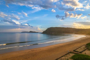 Central Coast, NSW, Avustralya 'daki Umina Sahili' nde yağmur bulutları ve atmosferli gün batımı.
