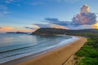 Central Coast, NSW, Avustralya 'daki Umina Sahili' nde yağmur bulutları ve atmosferli gün batımı.