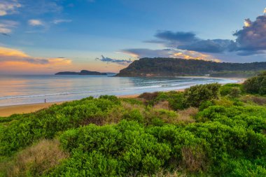 Central Coast, NSW, Avustralya 'daki Umina Sahili' nde yağmur bulutları ve atmosferli gün batımı.