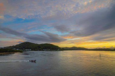 Kuzey Sahili, Avustralya 'da Woy Woy' da ilginç bulut oluşumlarıyla gün doğumu su manzarası..
