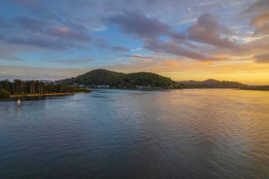 Kuzey Sahili, Avustralya 'da Woy Woy' da ilginç bulut oluşumlarıyla gün doğumu su manzarası..