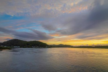 Kuzey Sahili, Avustralya 'da Woy Woy' da ilginç bulut oluşumlarıyla gün doğumu su manzarası..