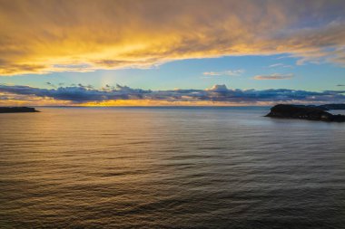 Bulut gündoğumunu atmosferle kapladı. Central Coast, NSW, Avustralya 'daki Pearl Beach' te..