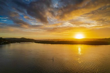 Kuzey Sahili, Avustralya 'da Woy Woy' da ilginç bulut oluşumlarıyla gün doğumu su manzarası..
