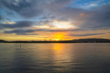Kuzey Sahili, Avustralya 'da Woy Woy' da ilginç bulut oluşumlarıyla gün doğumu su manzarası..