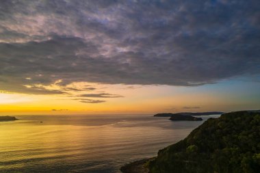 Umina Point 'teki Umina Sahili' nden NSW, Avustralya 'ya kadar bulutlarla birlikte gün doğumu denizi..