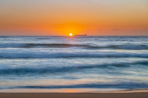 オーストラリア ニューサウスウェールズ州中央海岸のMacmasters Beachの地平線に船で日の出の海 — ストック写真