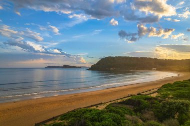Central Coast, NSW, Avustralya 'daki Umina Sahili' nde yağmur bulutları ve atmosferli gün batımı.