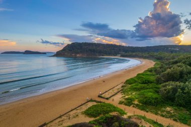 Central Coast, NSW, Avustralya 'daki Umina Sahili' nde yağmur bulutları ve atmosferli gün batımı.