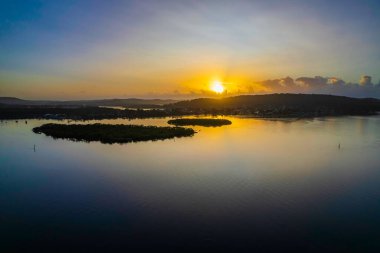 Merkezi Sahilde, NSW, Avustralya 'da Woy Woy' da volkanik külden sisli bir gökyüzü ile hava gündoğumu su manzarası.