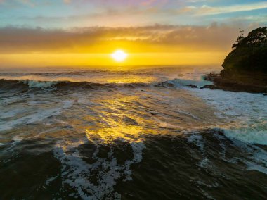 Merkezi Sahildeki Avoca Sahili, NSW, Avustralya 'da bulutlu, sisli ve deniz köpüklü gündoğumu denizi..