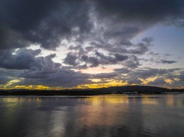 Körfezin üzerinde hava güneşinin doğuşu, yağmur bulutları Orta Sahildeki Woy Woy 'da, NSW, Avustralya.