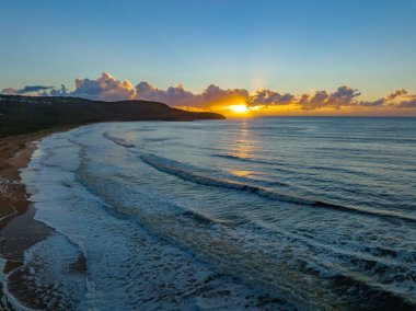 Central Coast, NSW, Avustralya 'daki Killcare Sahili' nde deniz köpüğü ve bulut kütleli gün doğumu denizi..