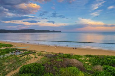 Central Coast, NSW, Avustralya 'daki Umina Sahili' nde yağmur bulutları ve atmosferli gün batımı.