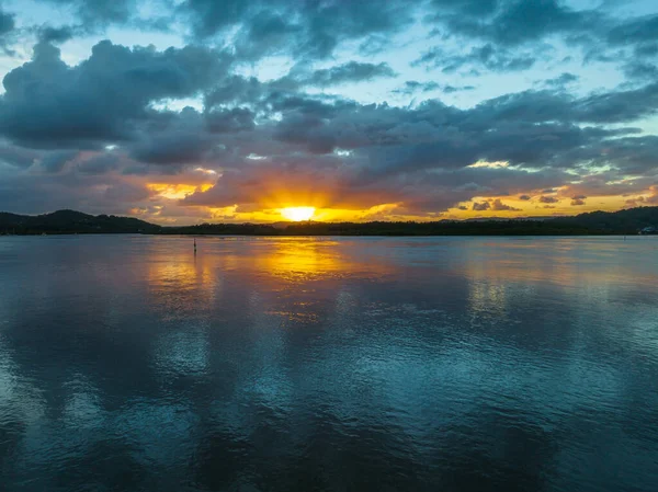 Körfezin üzerinde hava güneşinin doğuşu, yağmur bulutları Orta Sahildeki Woy Woy 'da, NSW, Avustralya.