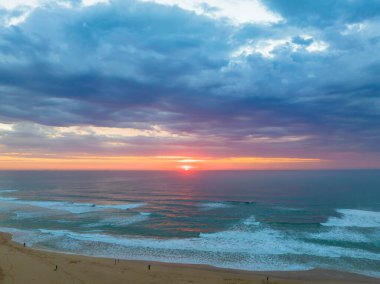 Avoca Lagoon 'un Avoca Sahili' nde NSW, Avustralya 'da pembe ve mavi bir hava gündoğumunun gölgeleri..