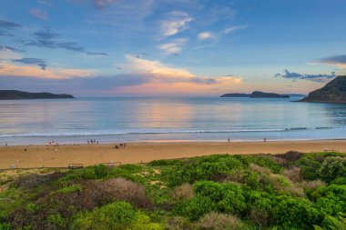 Central Coast, NSW, Avustralya 'daki Umina Sahili' nde yağmur bulutları ve atmosferli gün batımı.