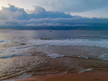 Central Coast, NSW, Avustralya 'daki Killcare Sahili' nde yağmur bulutlarıyla birlikte gün doğumu denizi..