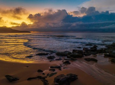 Central Coast, NSW, Avustralya 'daki Killcare Sahili' nde yağmur bulutlarıyla birlikte gün doğumu denizi..