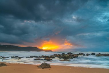 Deniz kenarında gün doğumu bulutlarla ve gökyüzünde pembe bir dokunuşla Central Coast, NSW, Avustralya 'daki Killcare Plajı' nda..