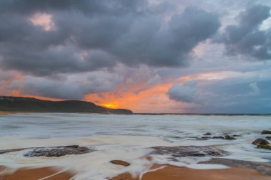 Deniz kenarında gün doğumu bulutlarla ve gökyüzünde pembe bir dokunuşla Central Coast, NSW, Avustralya 'daki Killcare Plajı' nda..