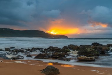 Deniz kenarında gün doğumu bulutlarla ve gökyüzünde pembe bir dokunuşla Central Coast, NSW, Avustralya 'daki Killcare Plajı' nda..