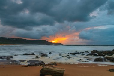 Deniz kenarında gün doğumu bulutlarla ve gökyüzünde pembe bir dokunuşla Central Coast, NSW, Avustralya 'daki Killcare Plajı' nda..