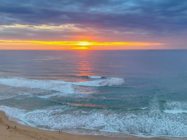Avoca Lagoon 'un Avoca Sahili' nde NSW, Avustralya 'da pembe ve mavi bir hava gündoğumunun gölgeleri..