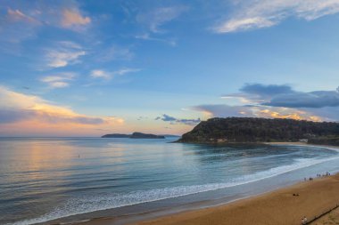 Central Coast, NSW, Avustralya 'daki Umina Sahili' nde yağmur bulutları ve atmosferli gün batımı.