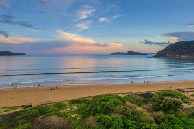 Central Coast, NSW, Avustralya 'daki Umina Sahili' nde yağmur bulutları ve atmosferli gün batımı.