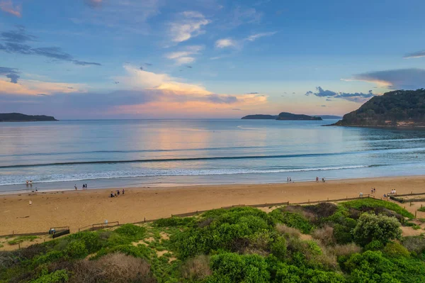 Central Coast, NSW, Avustralya 'daki Umina Sahili' nde yağmur bulutları ve atmosferli gün batımı.