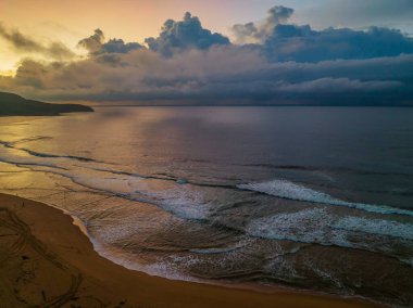 Central Coast, NSW, Avustralya 'daki Killcare Sahili' nde yağmur bulutlarıyla birlikte gün doğumu denizi..