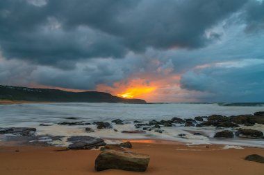 Deniz kenarında gün doğumu bulutlarla ve gökyüzünde pembe bir dokunuşla Central Coast, NSW, Avustralya 'daki Killcare Plajı' nda..