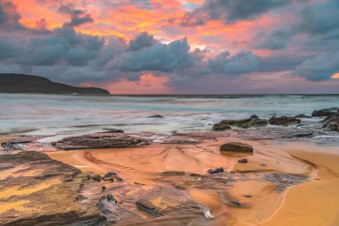 Deniz kenarında gün doğumu bulutlarla ve gökyüzünde pembe bir dokunuşla Central Coast, NSW, Avustralya 'daki Killcare Plajı' nda..
