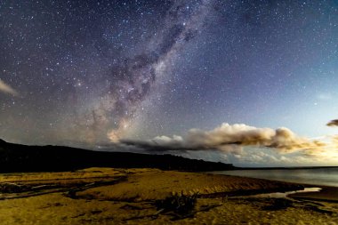 Gecenin karanlığında, Samanyolu 'nun altındaki sahilde ve Avustralya, NSW' nin merkez kıyısındaki Putty Beach 'te yıldızlar..