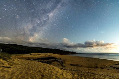 Gecenin karanlığında, Samanyolu 'nun altındaki sahilde ve Avustralya, NSW' nin merkez kıyısındaki Putty Beach 'te yıldızlar..