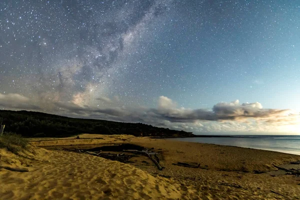 Gecenin karanlığında, Samanyolu 'nun altındaki sahilde ve Avustralya, NSW' nin merkez kıyısındaki Putty Beach 'te yıldızlar..