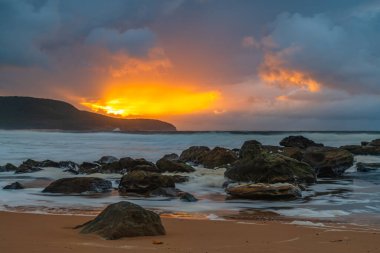 Deniz kenarında gün doğumu bulutlarla ve gökyüzünde pembe bir dokunuşla Central Coast, NSW, Avustralya 'daki Killcare Plajı' nda..