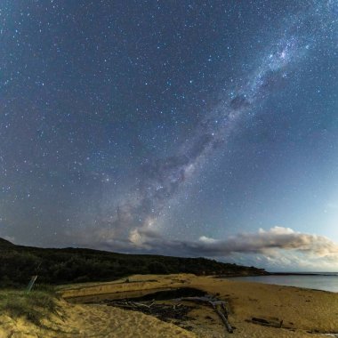Gecenin karanlığında, Samanyolu 'nun altındaki sahilde ve Avustralya, NSW' nin merkez kıyısındaki Putty Beach 'te yıldızlar..