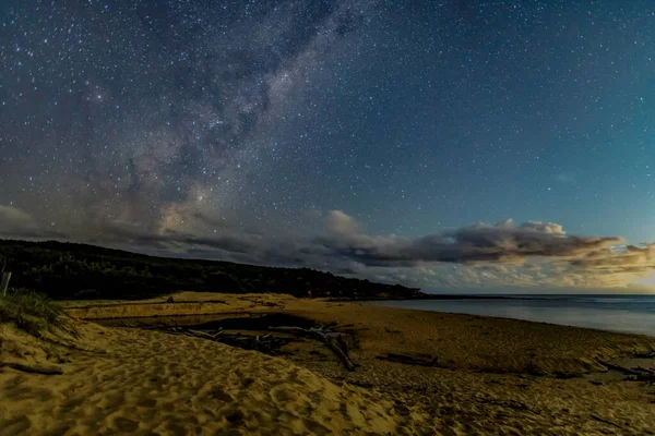 Gecenin karanlığında, Samanyolu 'nun altındaki sahilde ve Avustralya, NSW' nin merkez kıyısındaki Putty Beach 'te yıldızlar..