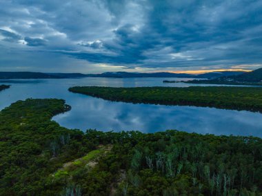 Central Coast, NSW, Avustralya 'daki Woy Woy' da yağmur bulutlarıyla birlikte havadan gün doğumu manzarası..