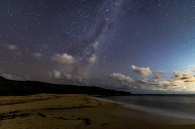 Gecenin karanlığında, Samanyolu 'nun altındaki sahilde ve Avustralya, NSW' nin merkez kıyısındaki Putty Beach 'te yıldızlar..