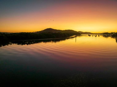 Central Coast, NSW, Avustralya 'daki Woy Woy' da bulutsuz bir gökyüzü ile hava gündoğumu su manzarası..