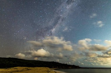 Gecenin karanlığında, Samanyolu 'nun altındaki sahilde ve Avustralya, NSW' nin merkez kıyısındaki Putty Beach 'te yıldızlar..